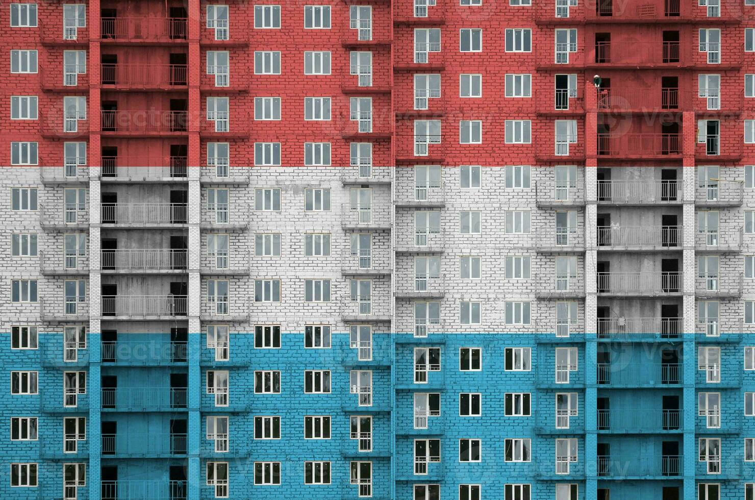 Luxembourg drapeau représenté dans peindre couleurs sur à plusieurs étages résidentielle bâtiment en dessous de construction. texturé bannière sur brique mur Contexte photo