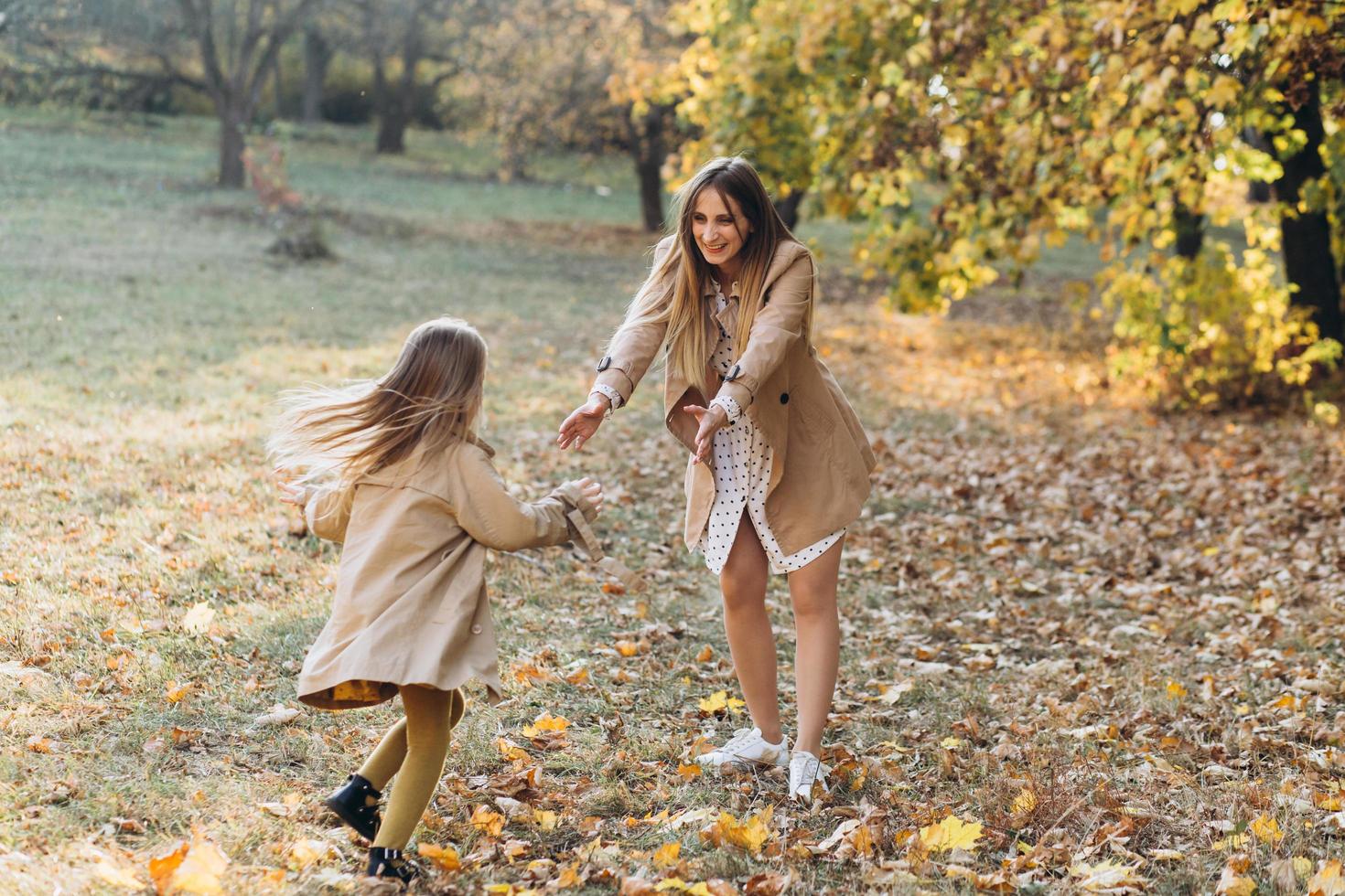 la mère et sa fille s'amusent et se promènent dans le parc en automne. photo