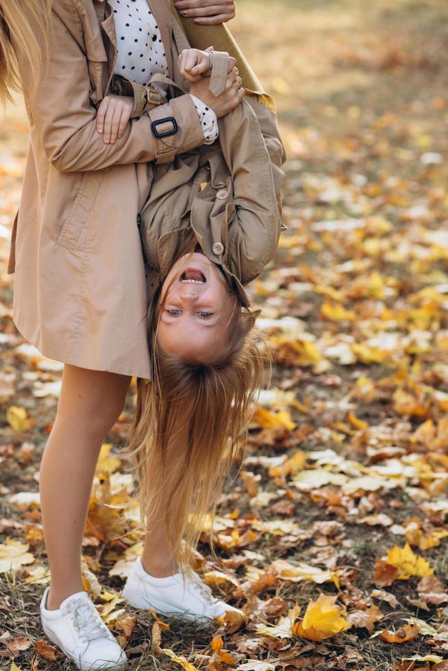 la mère et sa fille s'amusent et se promènent dans le parc en automne. photo
