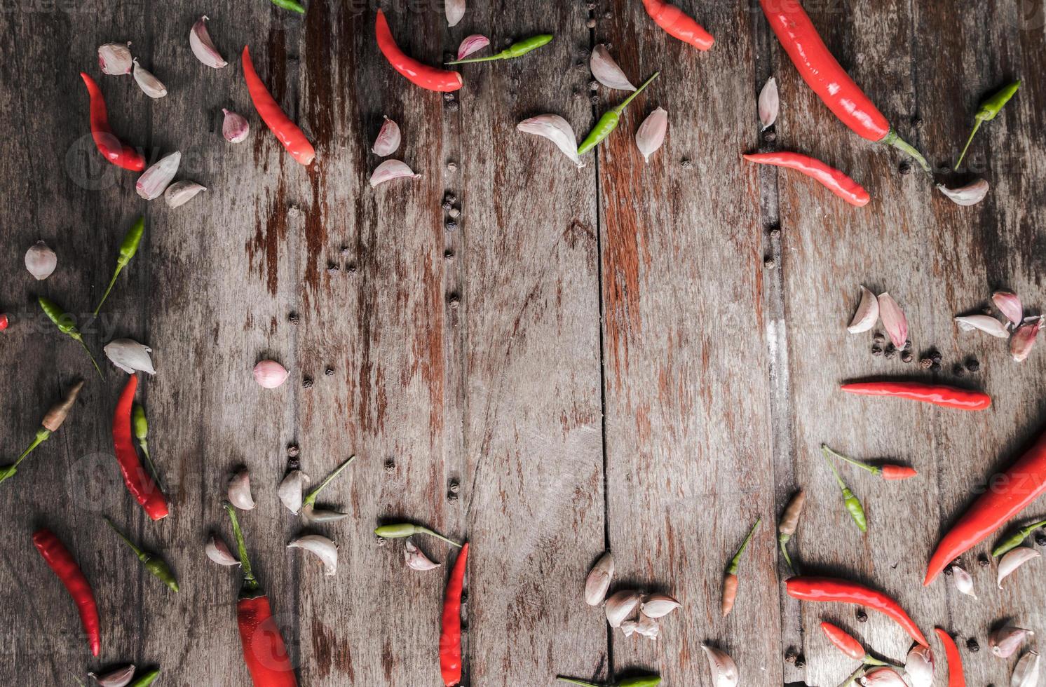 piment rouge frais et ail avec des graines de poivre sur fond de bois photo