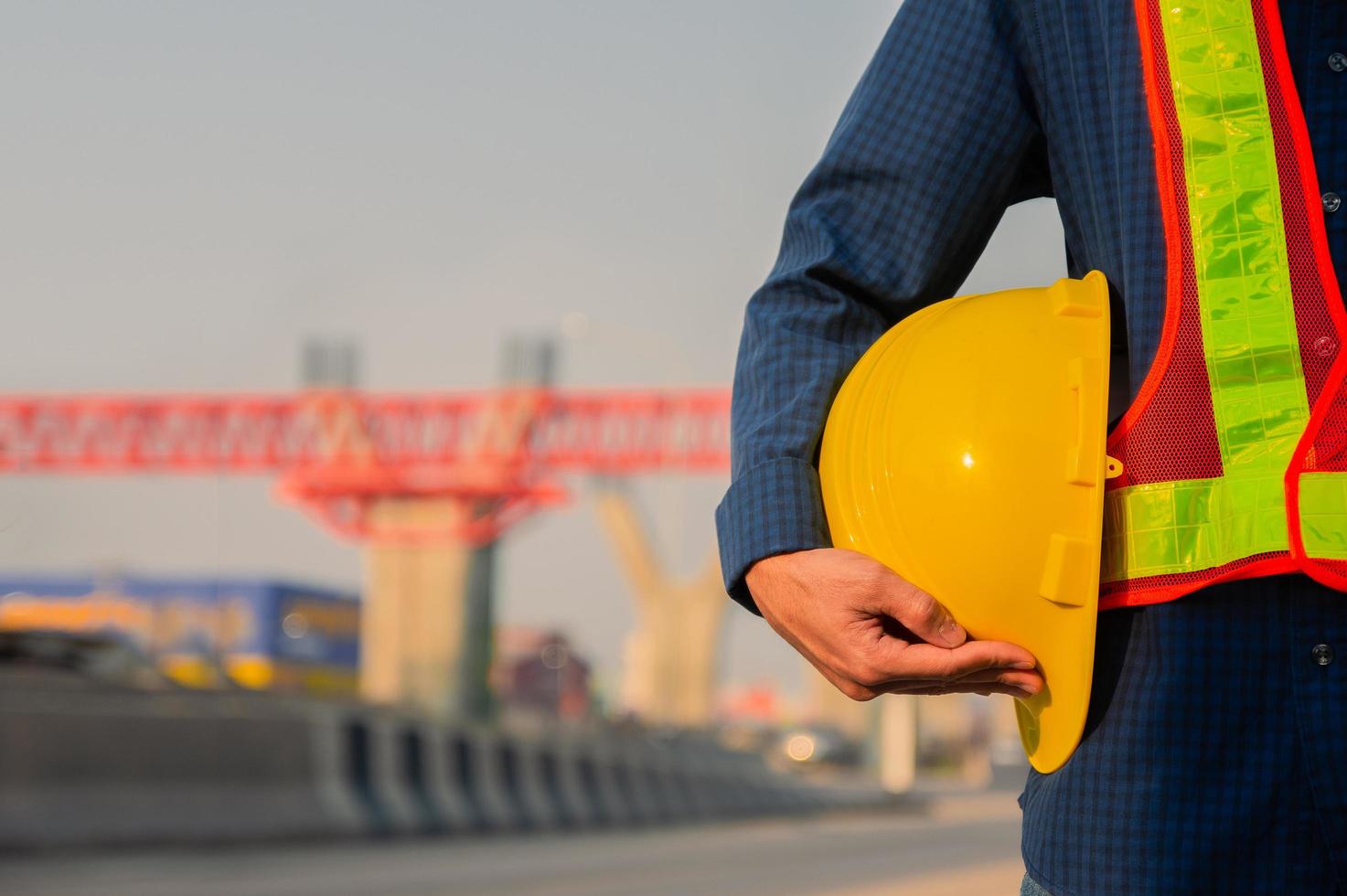 technicien tenant un chapeau jaune casque de sécurité fond de lumière du soleil photo