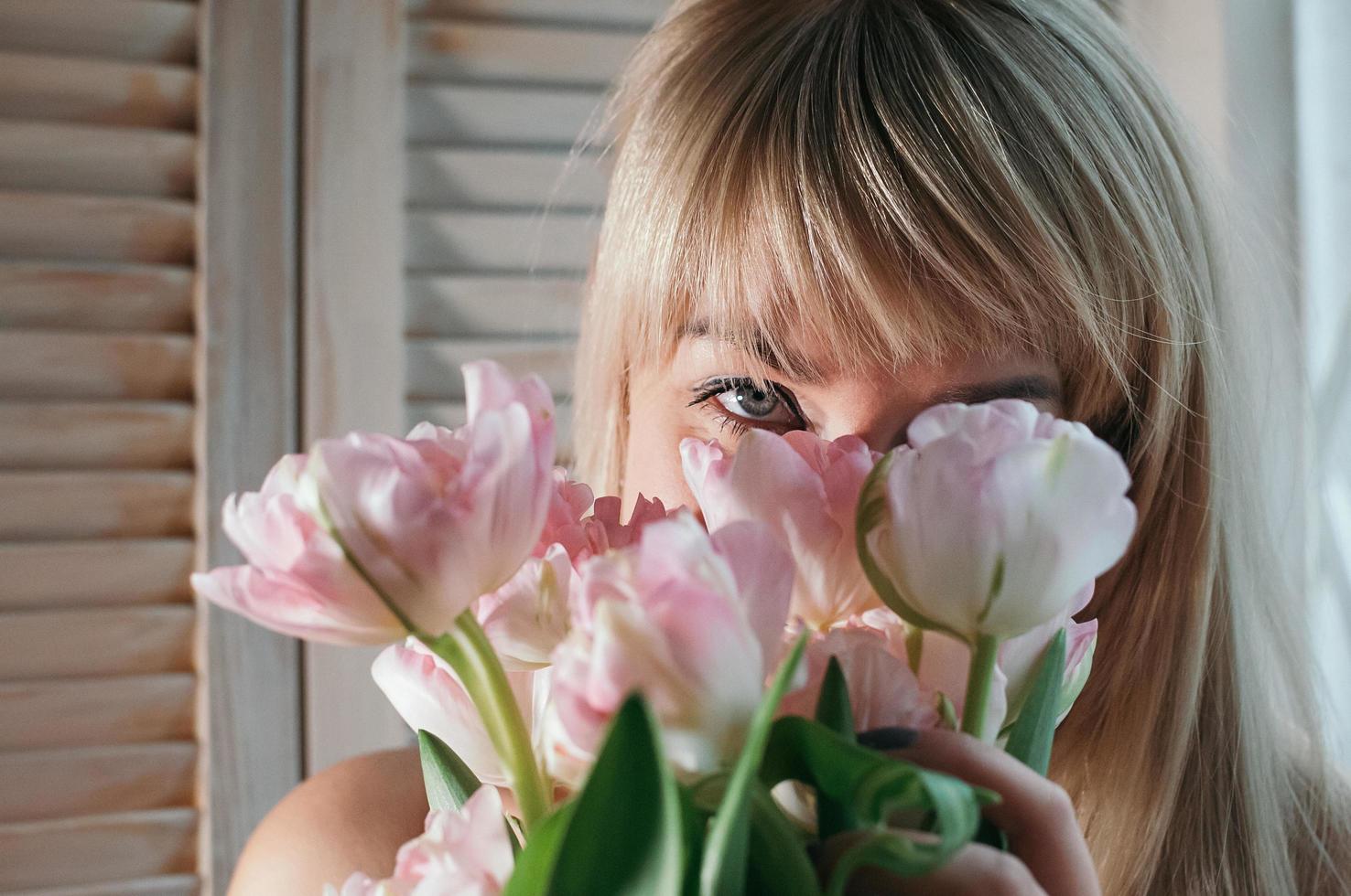 femme se cachant derrière des fleurs photo