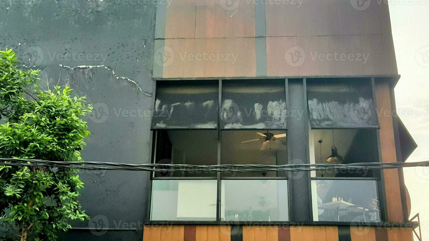vue de à l'extérieur de le fenêtre de une café resto avec une plafond ventilateur photo