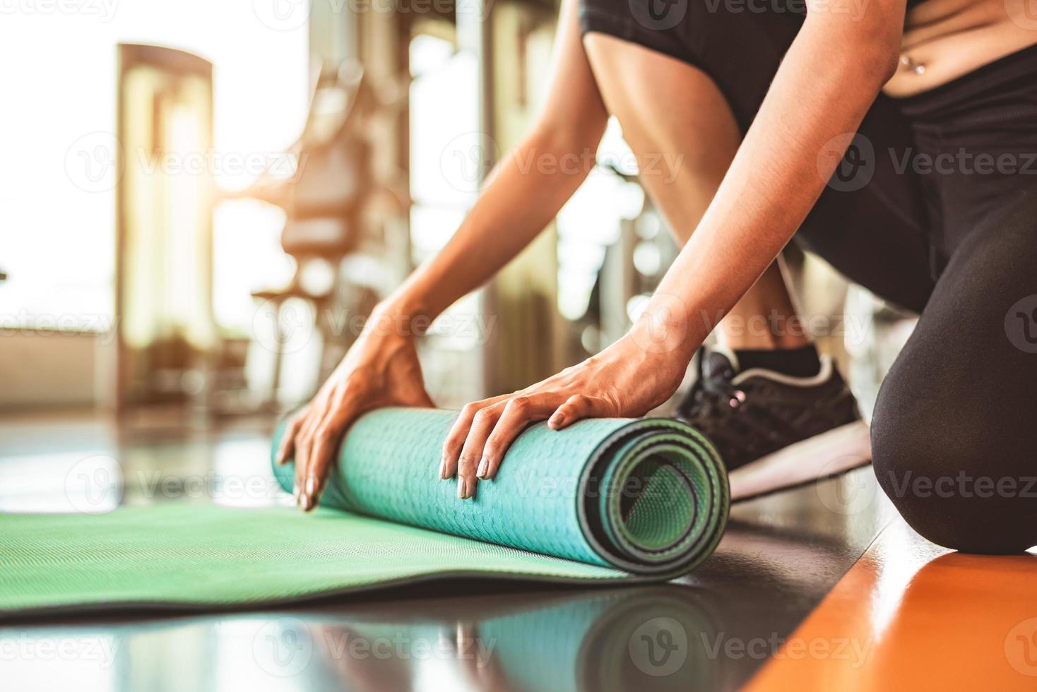 Close up of sporty woman pliage matelas de yoga photo