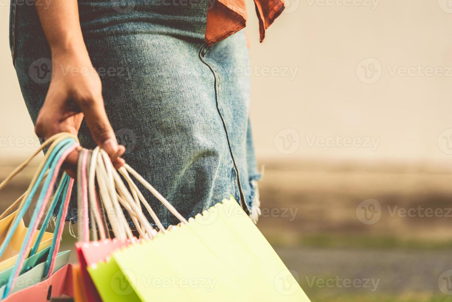 Gros plan sur une femme tenant un sac à provisions en papier de couleur photo
