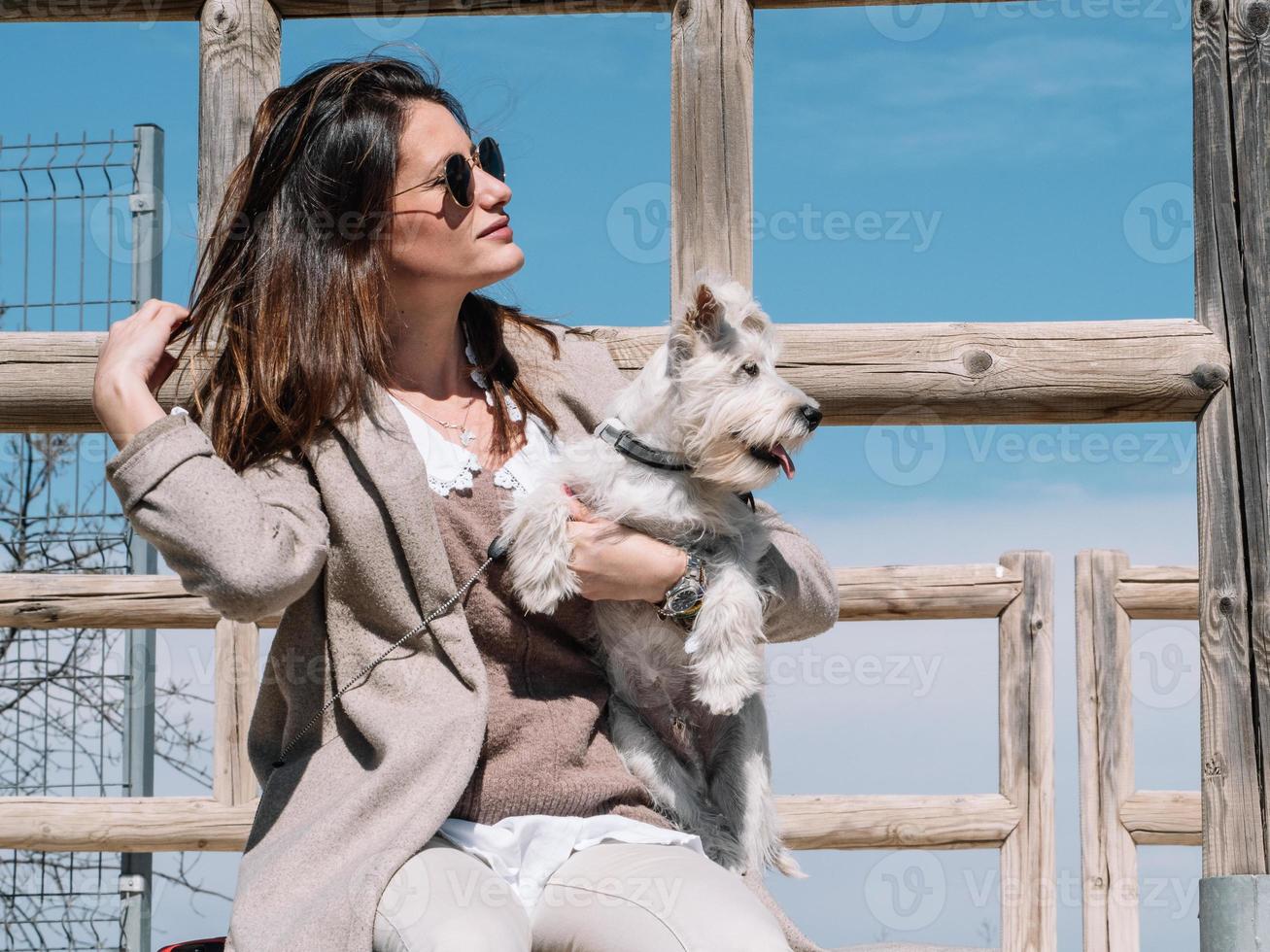 Femme avec chien schnauzer pose assis sur la balustrade photo