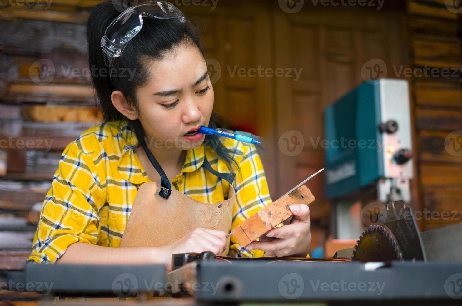 femme tenant une règle et un crayon tout en faisant des marques photo