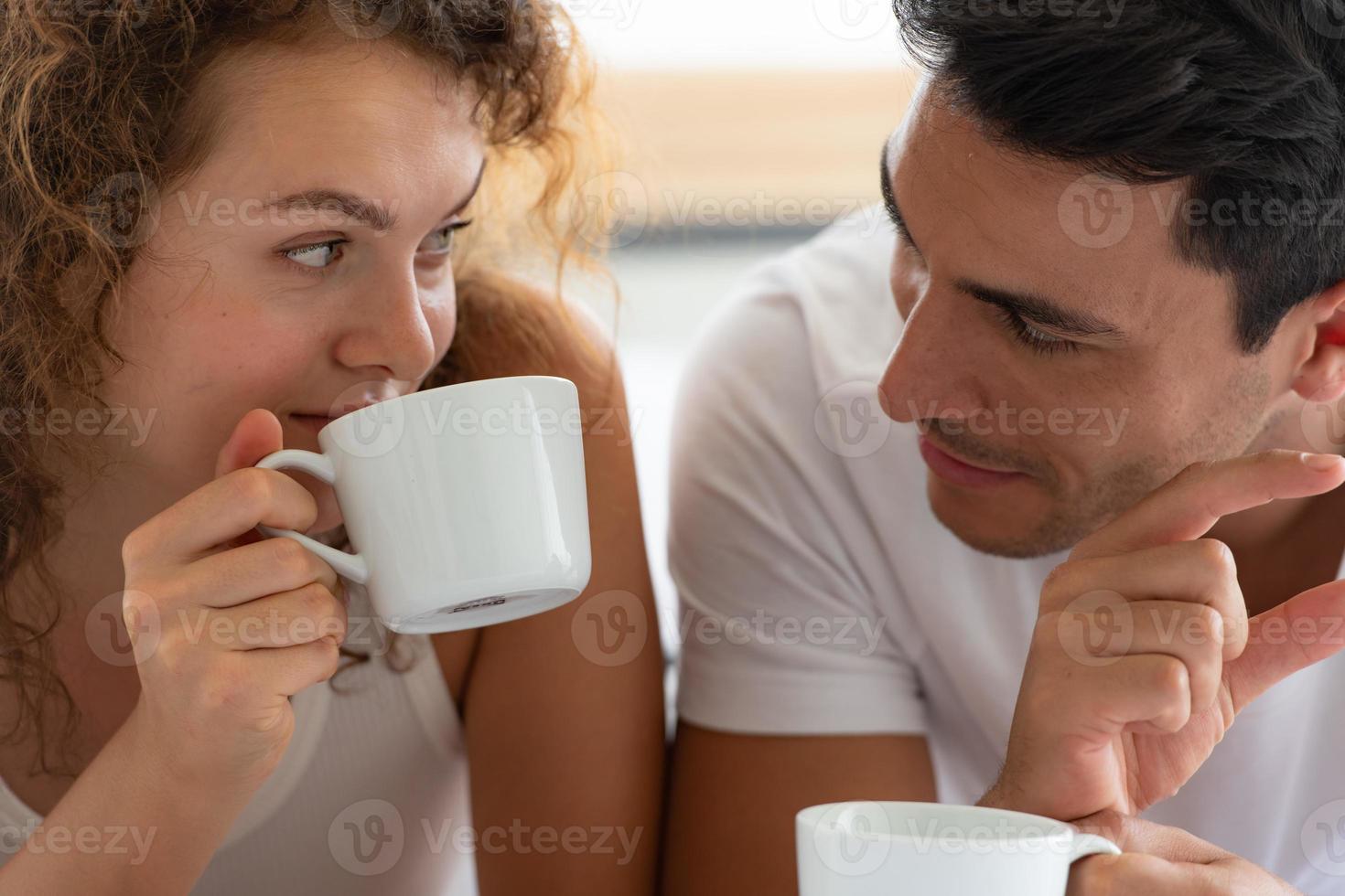 couples heureux se détendre dans la chambre blanche de l'appartement photo