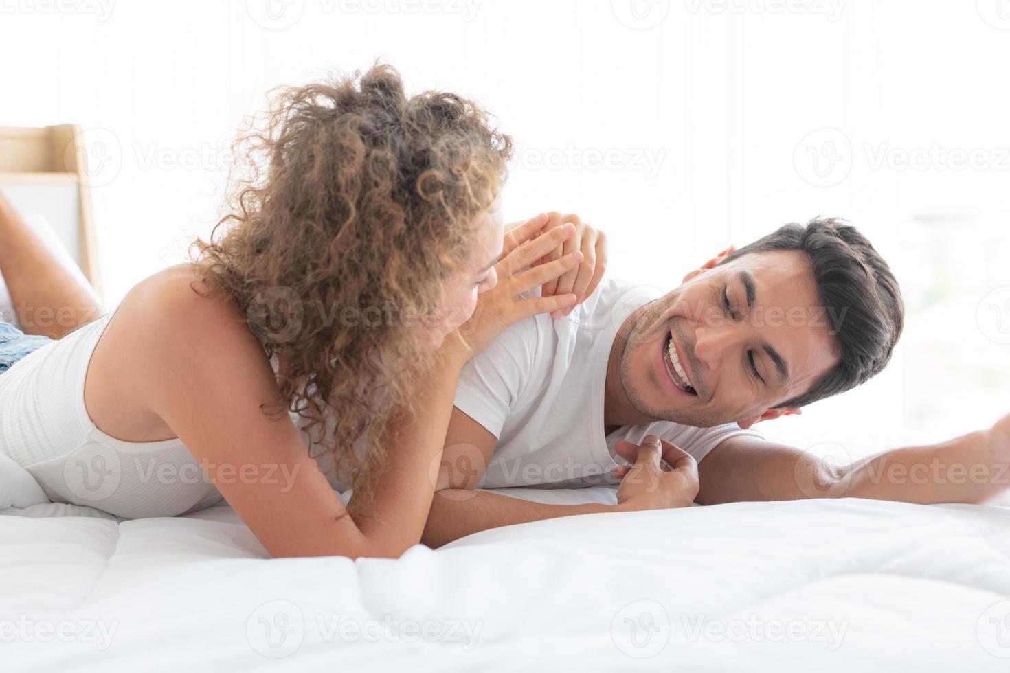 couples heureux se détendre dans la chambre blanche de l'appartement photo