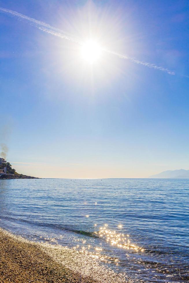 le chemtrail traverse le soleil au-dessus de la plage de l'île de kos en grèce. photo