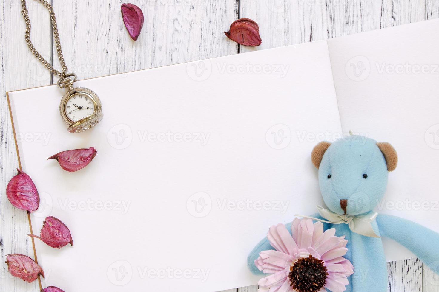 table en bois peint en blanc pétales de fleurs violettes ours horloge de poche poupée photo