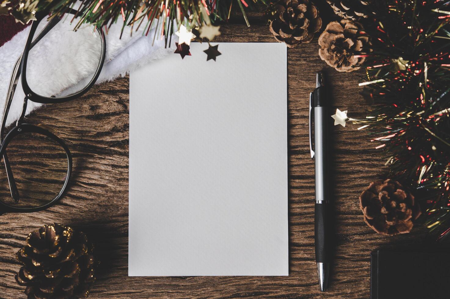 une carte vierge, des lunettes et un stylo sont placés sur du bois. photo