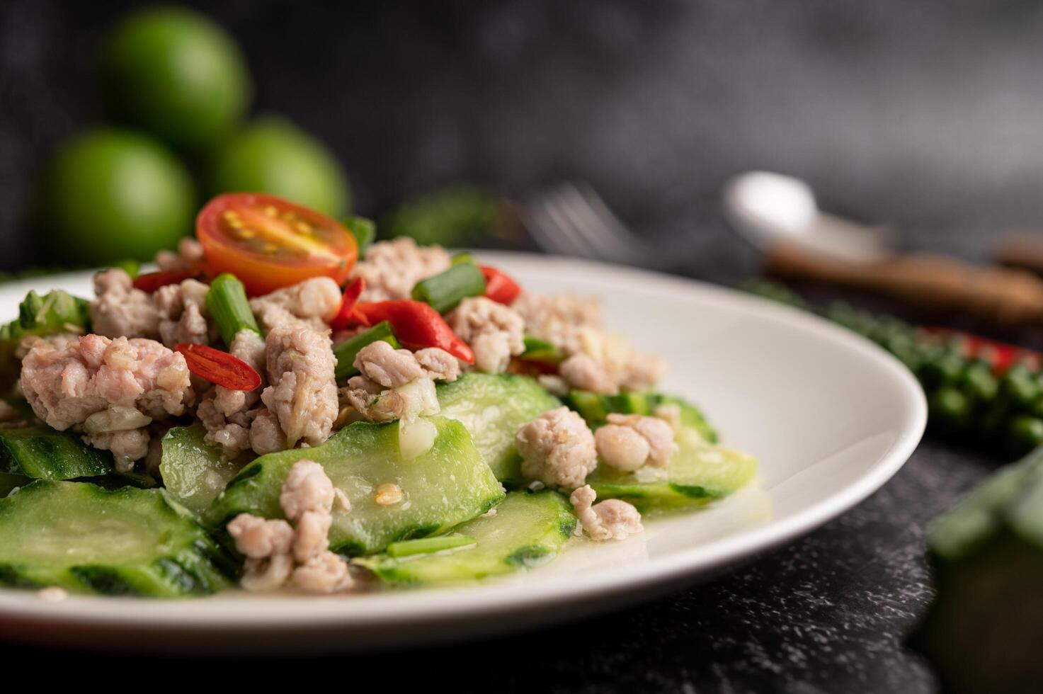 courgettes sautées avec du porc émincé dans une assiette blanche photo