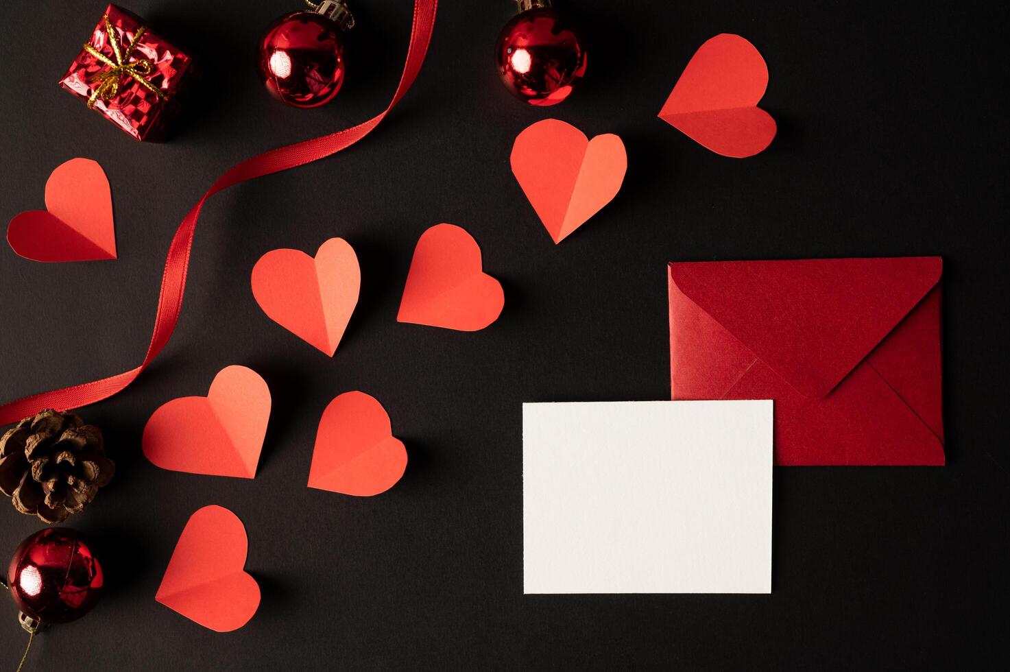 papier blanc et papier coeur rouge collés sur fond noir. photo