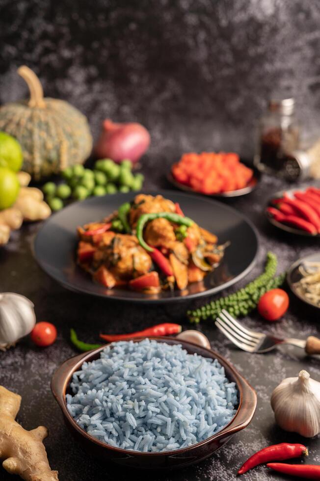 riz aux fleurs de pois papillon dans une tasse brune aux épices sur ciment noir. photo