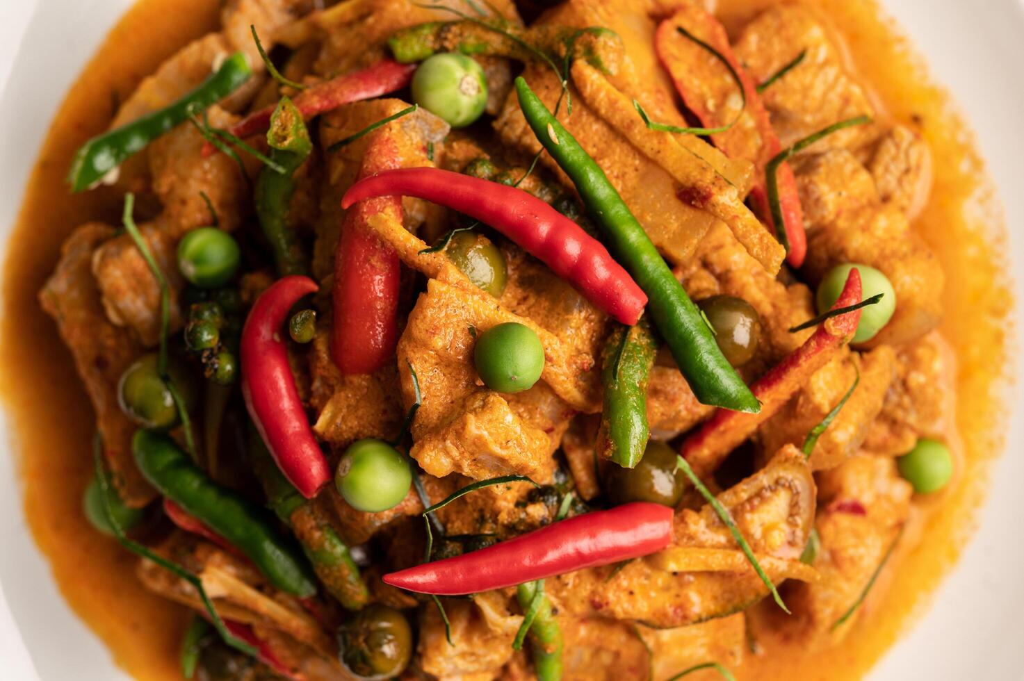 curry rouge avec du porc dans une assiette blanche photo