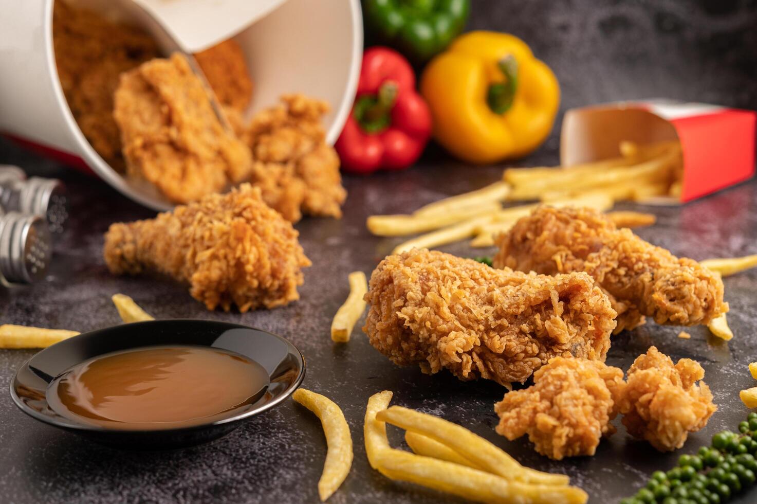 poulet frit et frites sur sol en ciment noir. photo