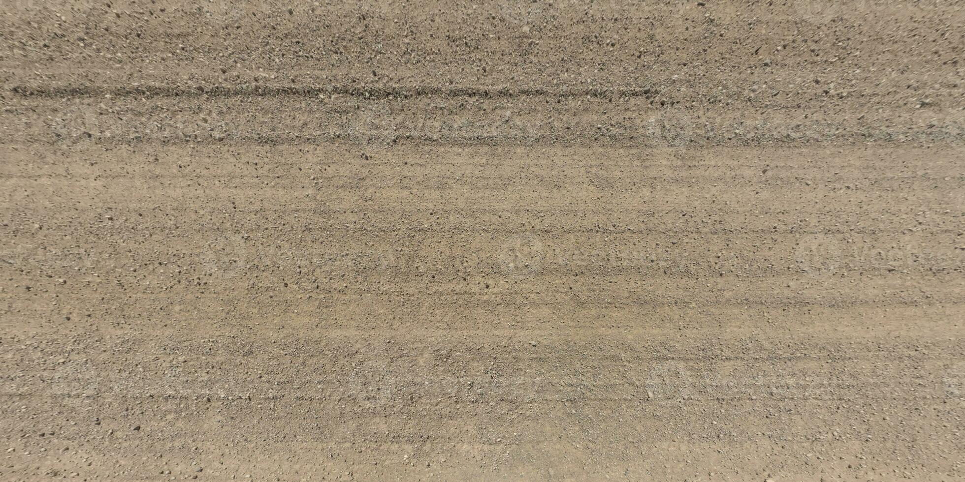 panorama de route de au dessus sur surface de gravier route avec voiture pneu des pistes dans campagne photo