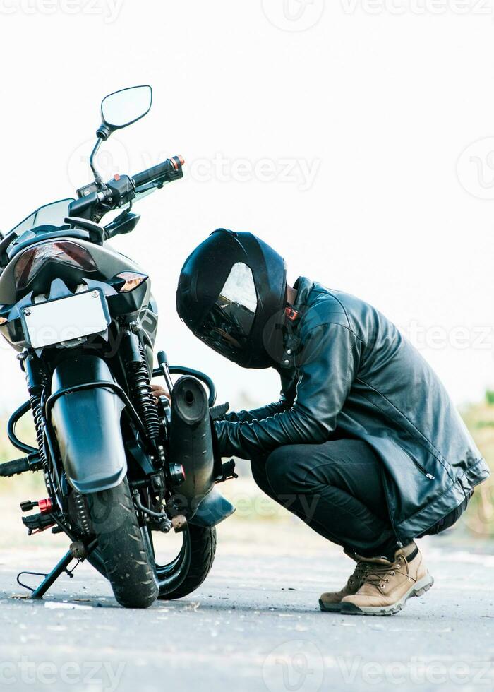 homme vérification le sien moto sur le route. motocycliste fixation le moto sur le route, motard réparer moto sur le route photo