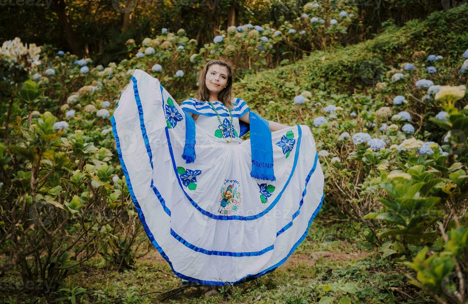 fille dans nicaraguayen nationale populaire costume. Jeune nicaraguayen femme dans traditionnel populaire costume dans une champ de les myflores, souriant fille dans nationale populaire costume dans une champ entouré par fleurs photo