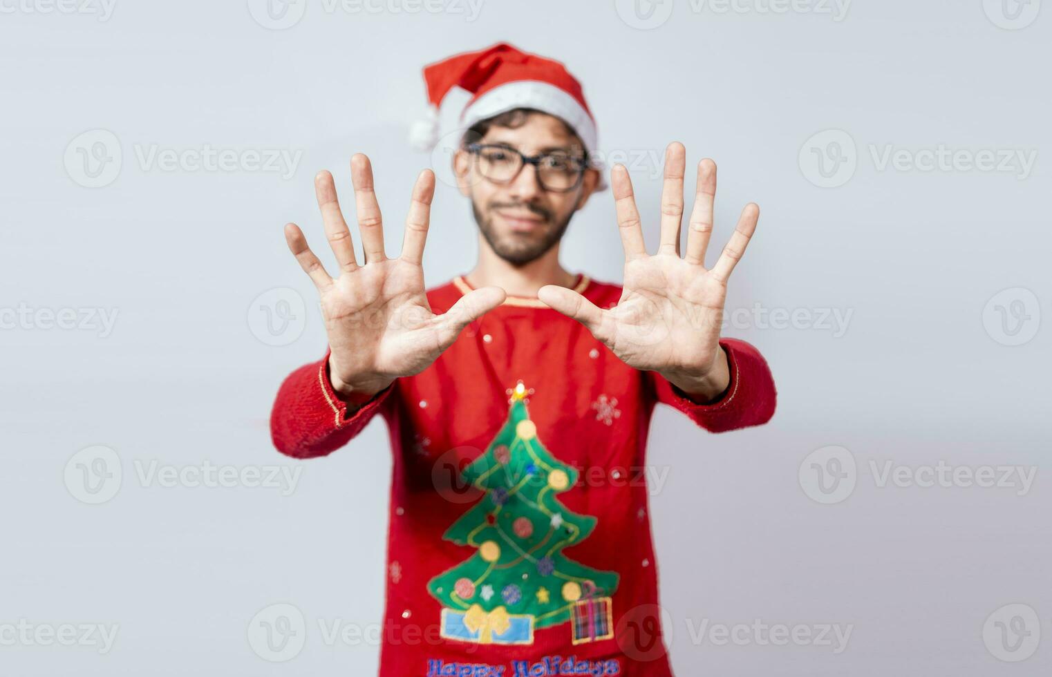 homme dans Noël chapeau compte nombre Dix avec des doigts. Noël Jeune homme compte nombre Dix avec mains. concept de homme dans Noël costume compte nombre Dix isolé photo