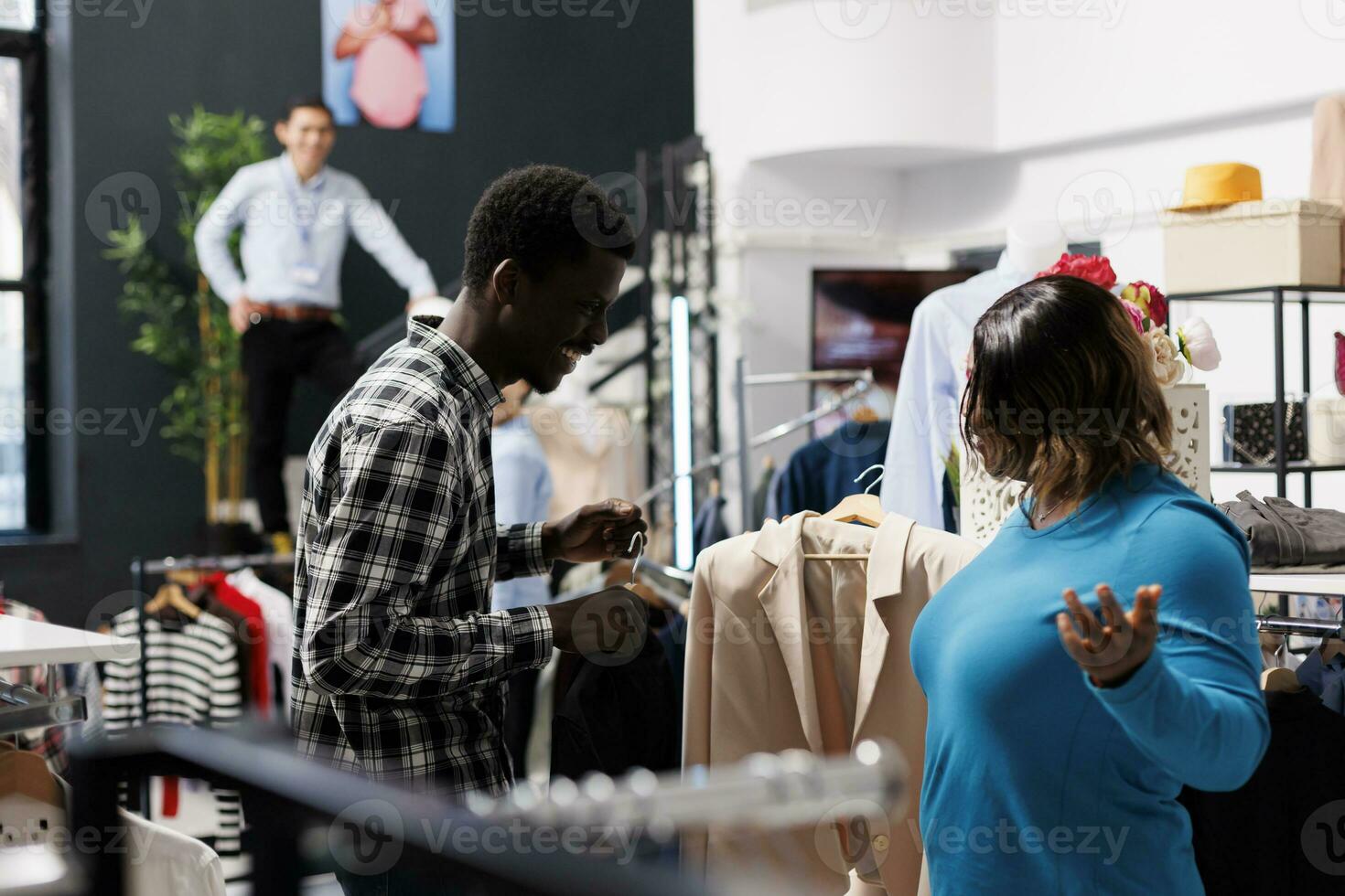 africain américain client discuter vêtements tissu, à la recherche à racks  plein avec à la mode marchandise dans Vêtements magasin. élégant femme  choisir à acheter décontractée porter dans moderne boutique 31408426 Photo