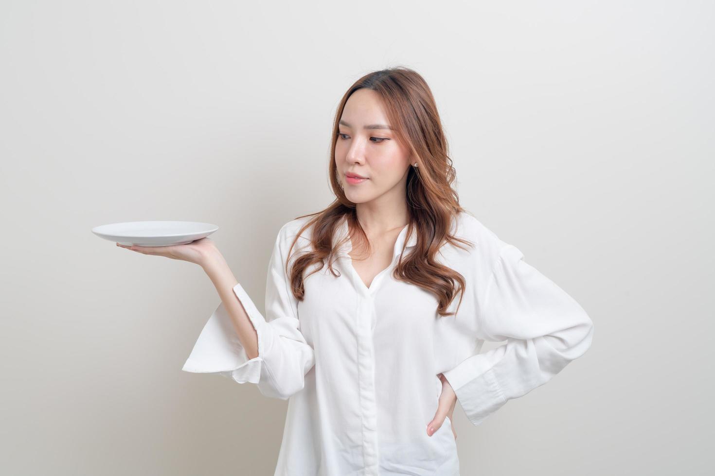 portrait belle femme asiatique tenant une assiette vide photo