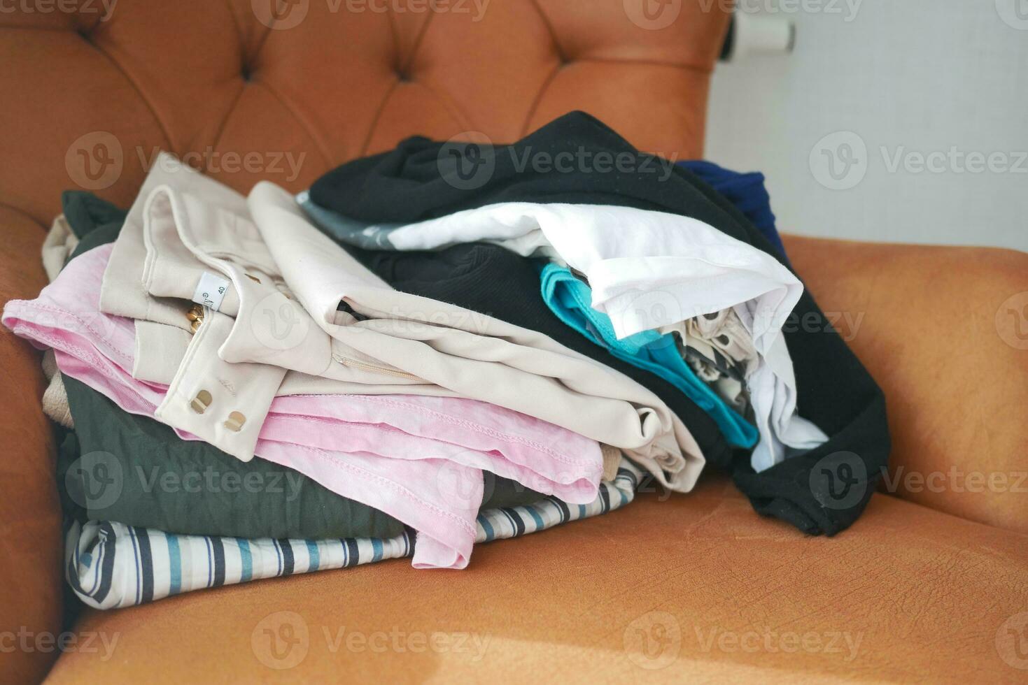 désordonné vêtements sur canapé à Accueil photo