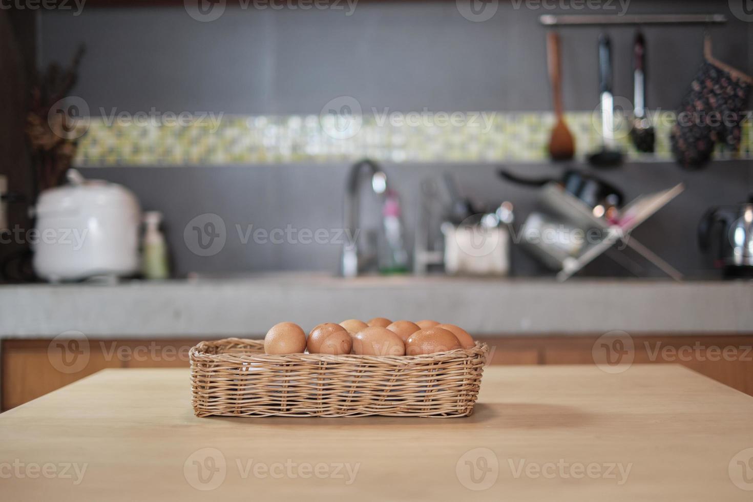des œufs frais de la ferme entassés dans des paniers en bois dans la cuisine de la maison. photo