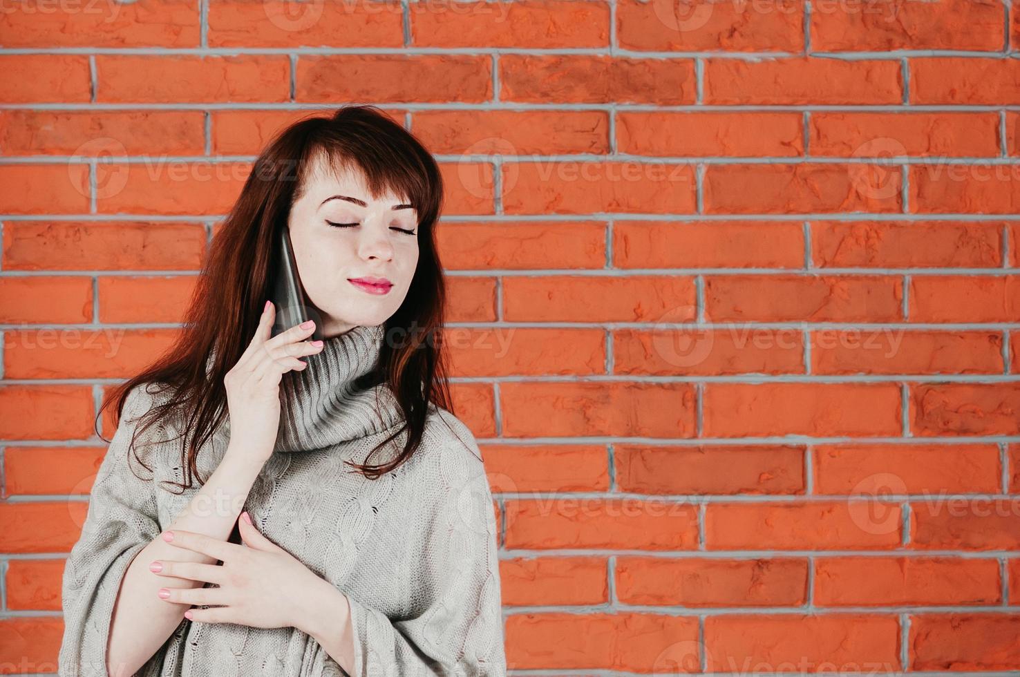 jolie fille parlant par téléphone portable, les yeux fermés, souriant rêveusement photo