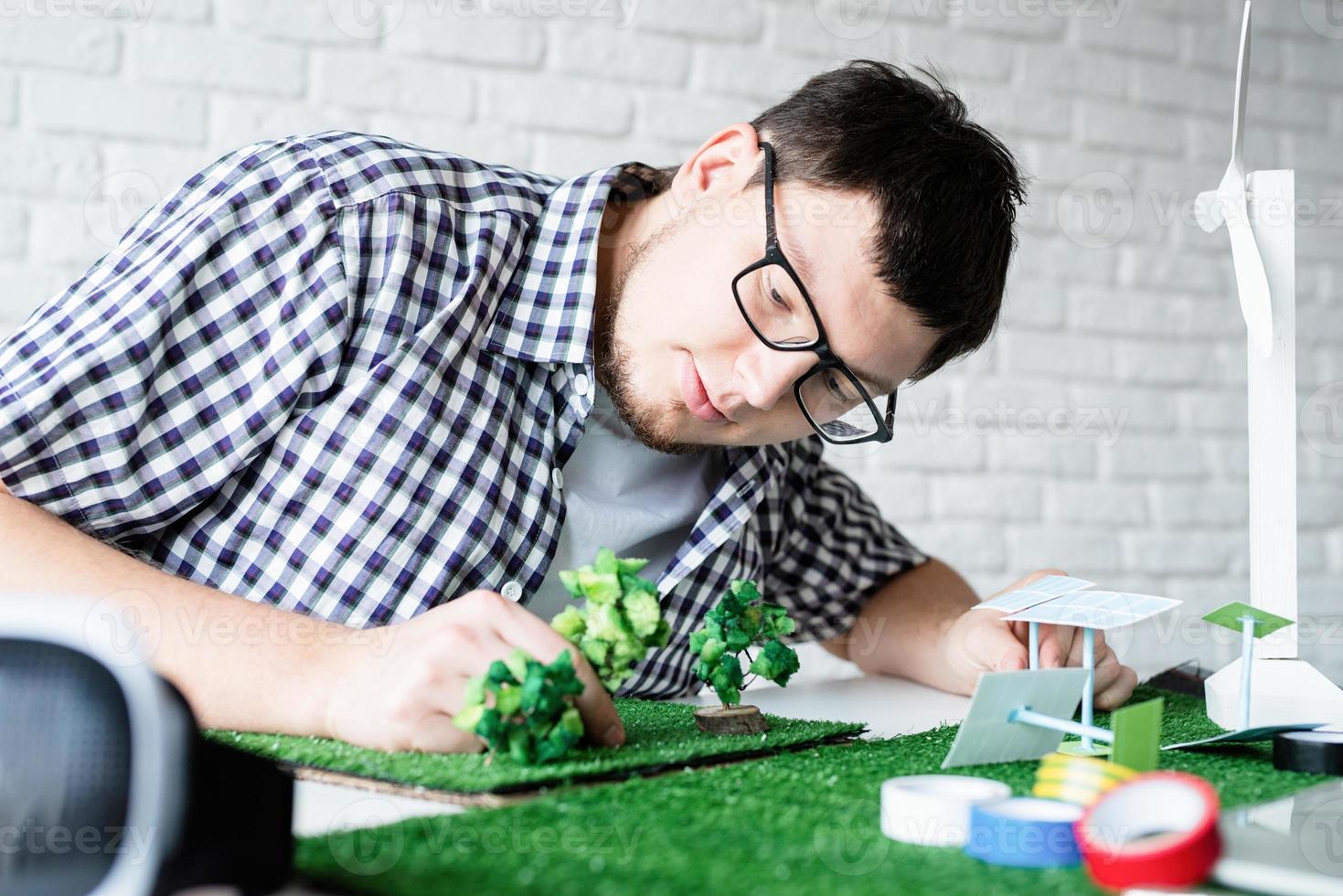 Jeune homme faisant un mannequin de projet d'énergie renouvelable photo