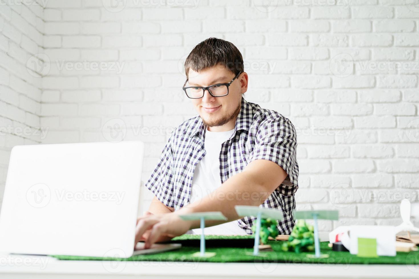jeune homme enseignant en ligne faisant un mannequin d'énergie renouvelable photo