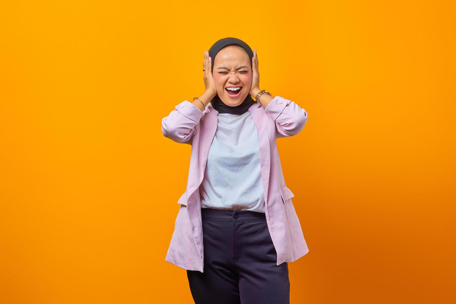portrait d'une femme d'affaires riant couvrant ses oreilles photo