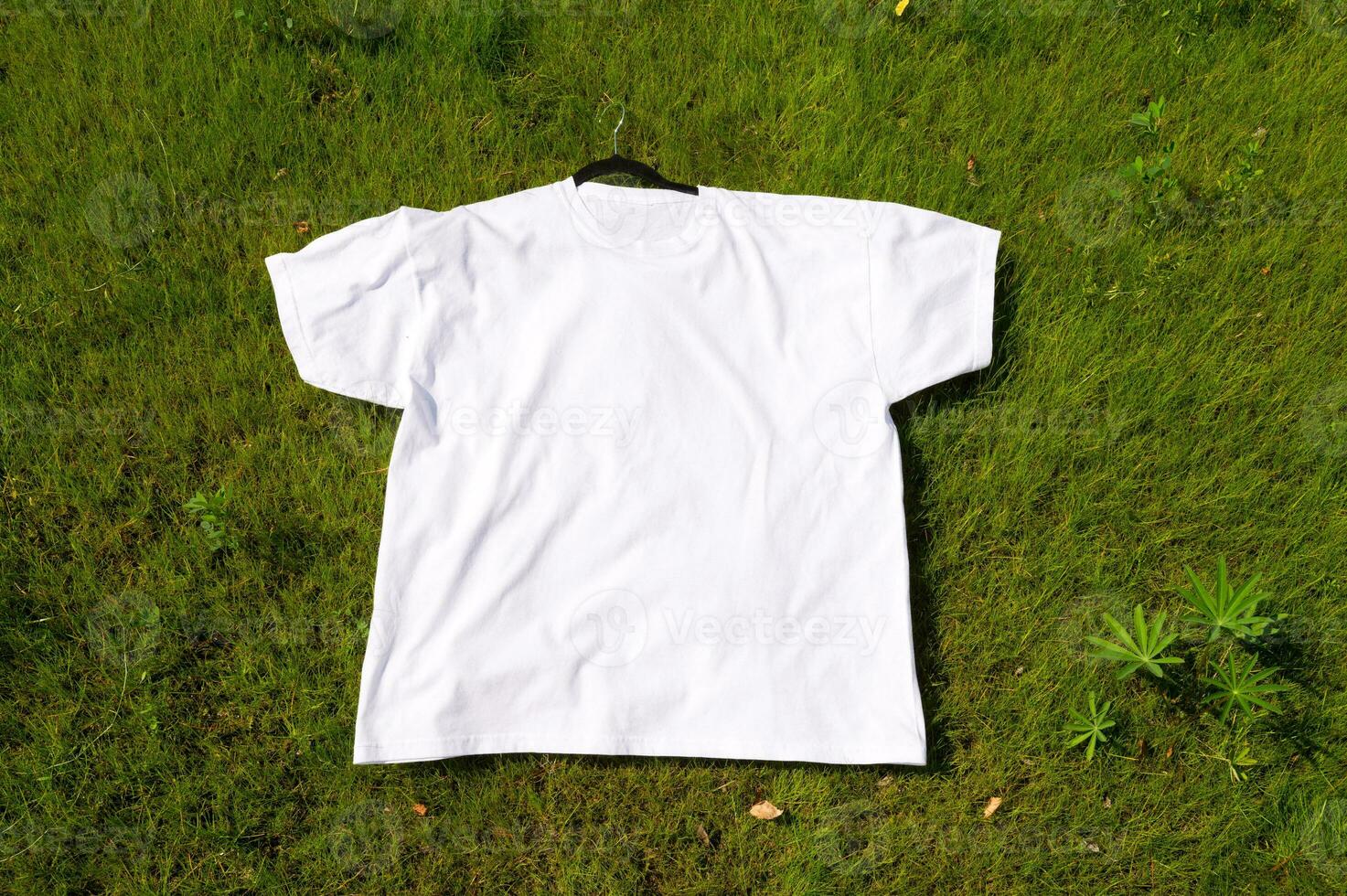 une blanc T-shirt est mensonge sur le herbe photo