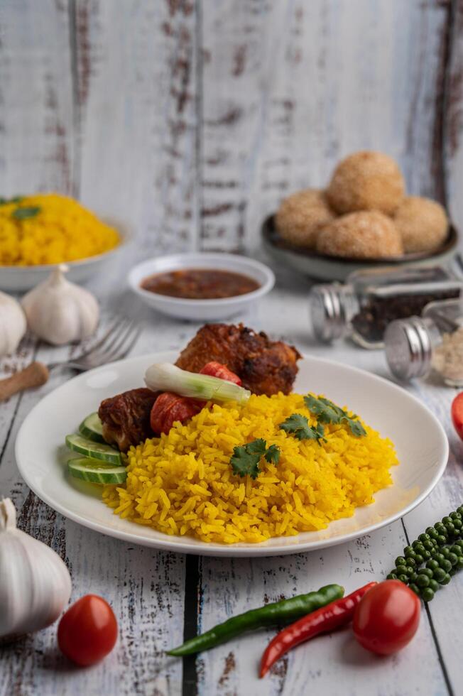 poulet biryani dans une assiette avec des épices sur un plancher en bois blanc photo