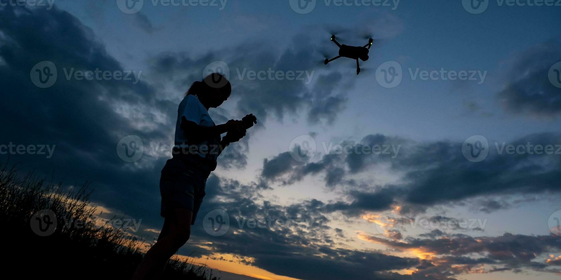 silhouette de femme contrôler drone sur le coucher du soleil Contexte photo