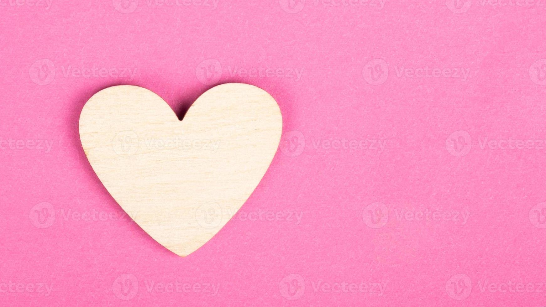 coeur en bois de la Saint-Valentin sur fond rose avec espace de copie photo