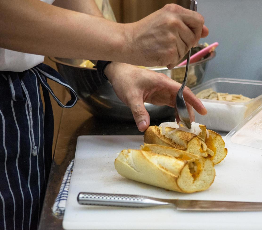 le chef prépare un sandwich dans la cuisine photo