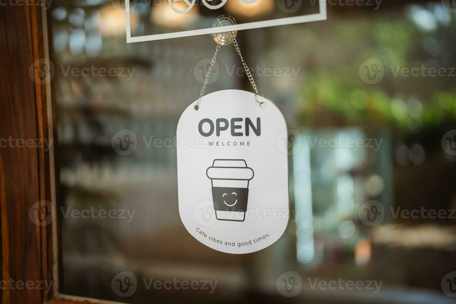 ouvert signe vaste par le porte verre bokeh Contexte. ouvert signe planche par le verre de boutique la fenêtre. texte en bois planche porte ancien magasin signe ouvert magasin. photo