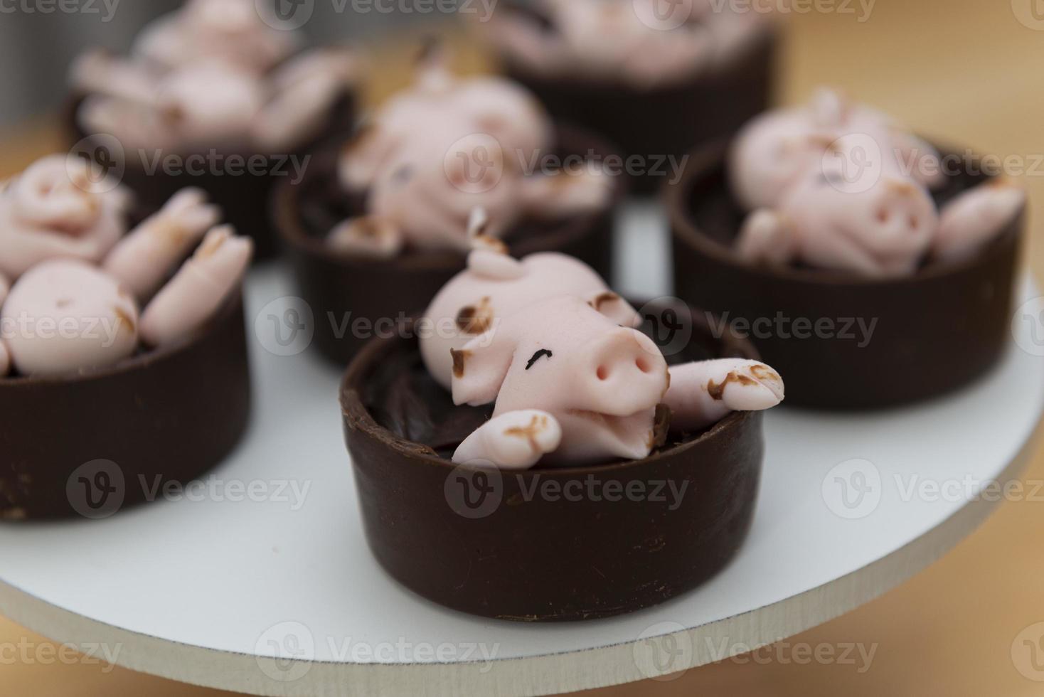 joyeux cochons roses mignons bonbons jouant dans la boue photo