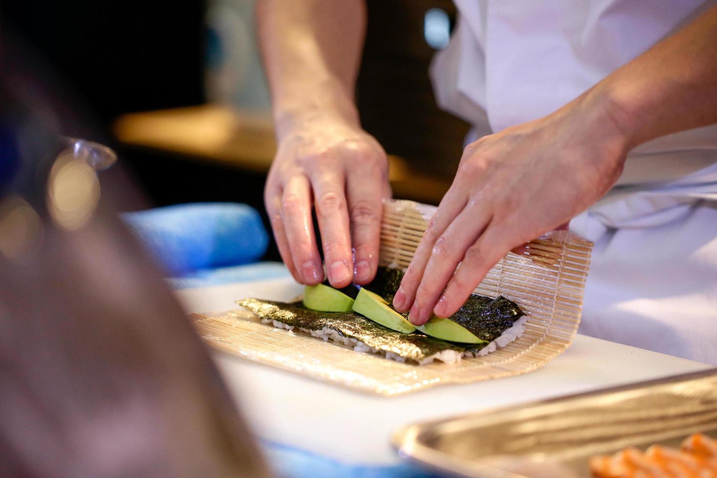 mains de chef préparant la nourriture japonaise, chef faisant des sushis photo