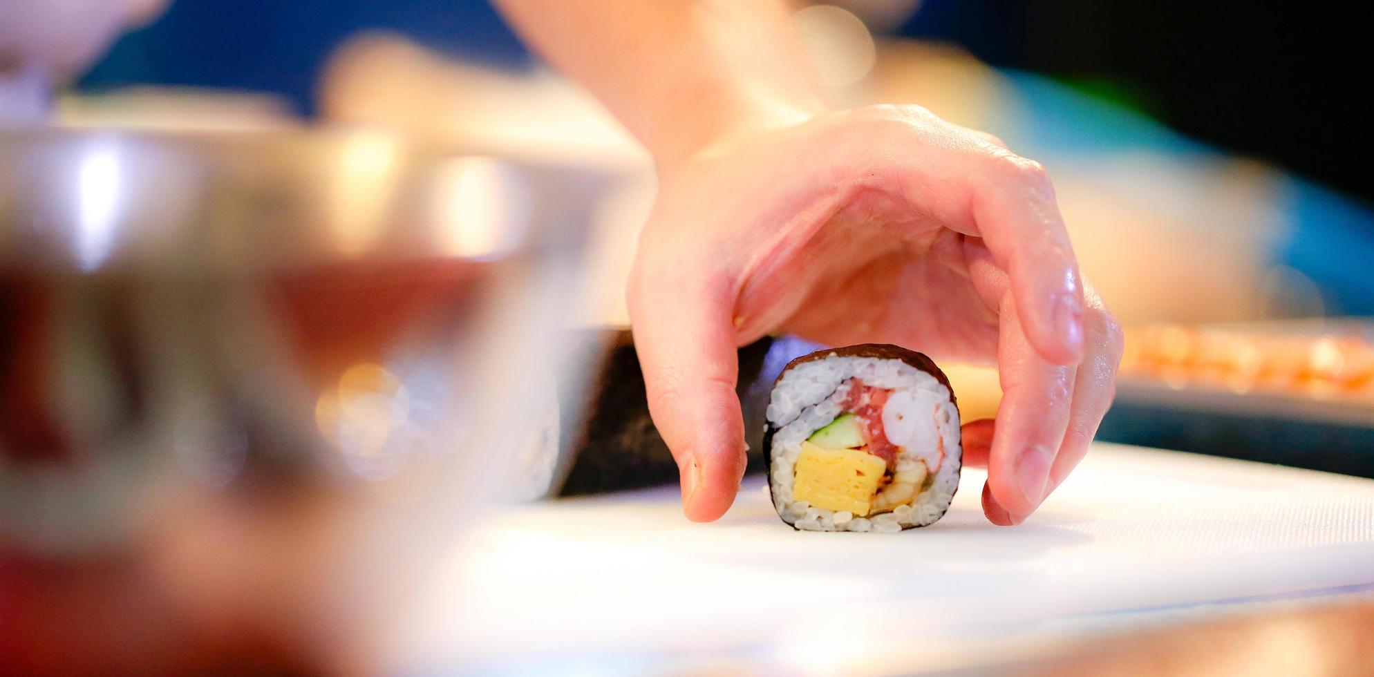 mains de chef préparant la nourriture japonaise, chef faisant des sushis photo