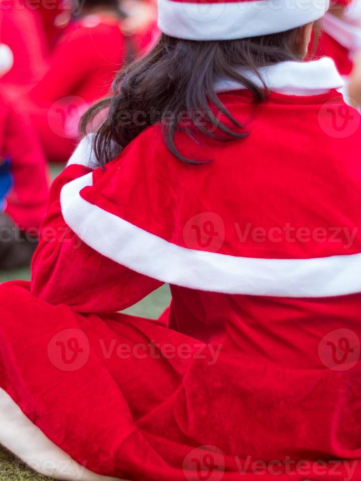 filles en costume de thème rouge dans la fête de noël de l'école primaire photo