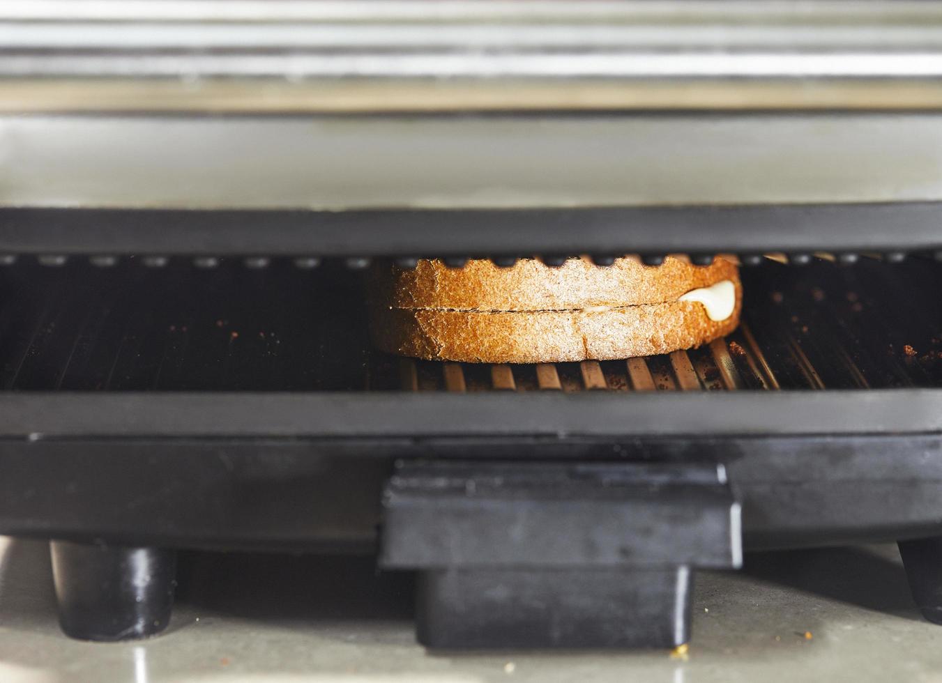 toast de deux tranches de pain et de fromage grillées dans un grille-pain photo