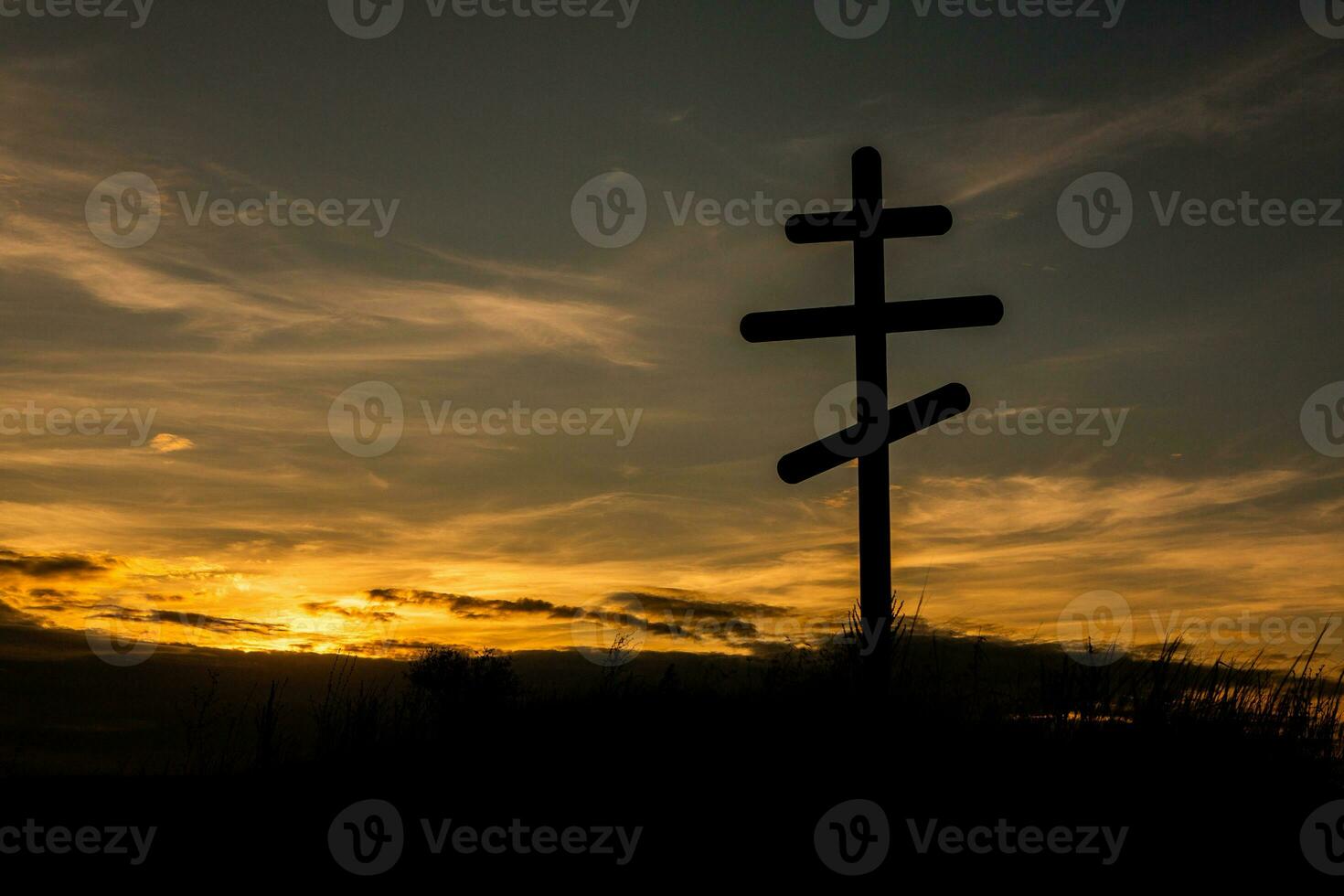 traverser sur Haut de une colline contre une bleu ciel avec blanc des nuages. silhouette de une traverser dans le champ à le coucher du soleil avec spectaculaire ciel. photo