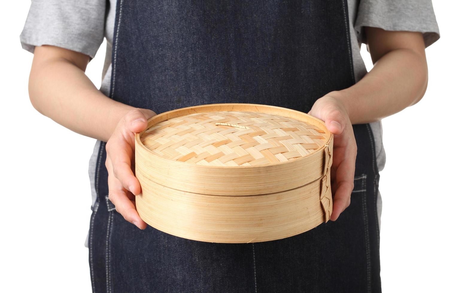 Chef tenant un panier de boulettes de bambou chinois vide sur fond blanc photo