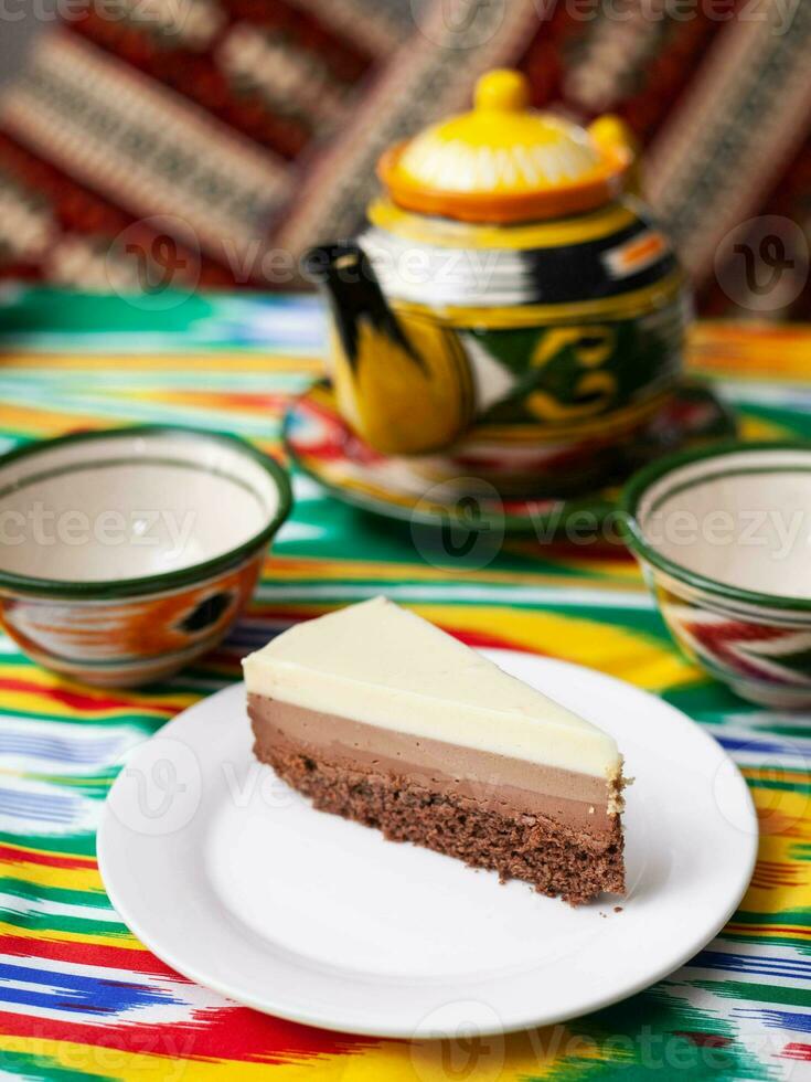 dessert cheesecake Trois des chocolats dans un Oriental style avec une théière et une tasse pour thé. photo