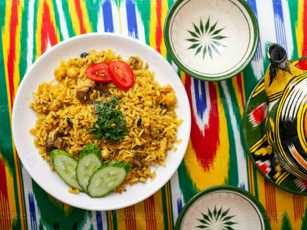 nationale ouzbek pilaf avec Viande sur le table dans le ouzbek style.on une table avec une théière et une tasse pour thé. photo