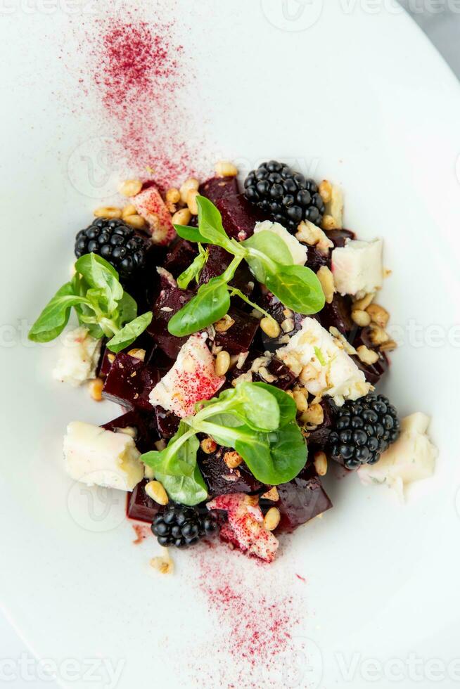 salade de mûres, betteraves, des graines et fromage, côté vue sur une blanc assiette photo