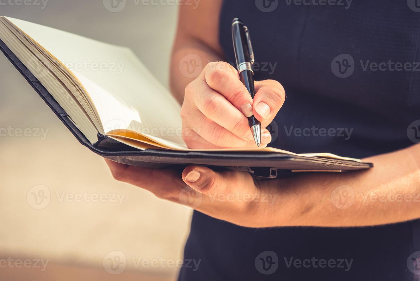 Libre de jeune femme écrivant une lettre dans le bloc-notes pour faire un journal photo